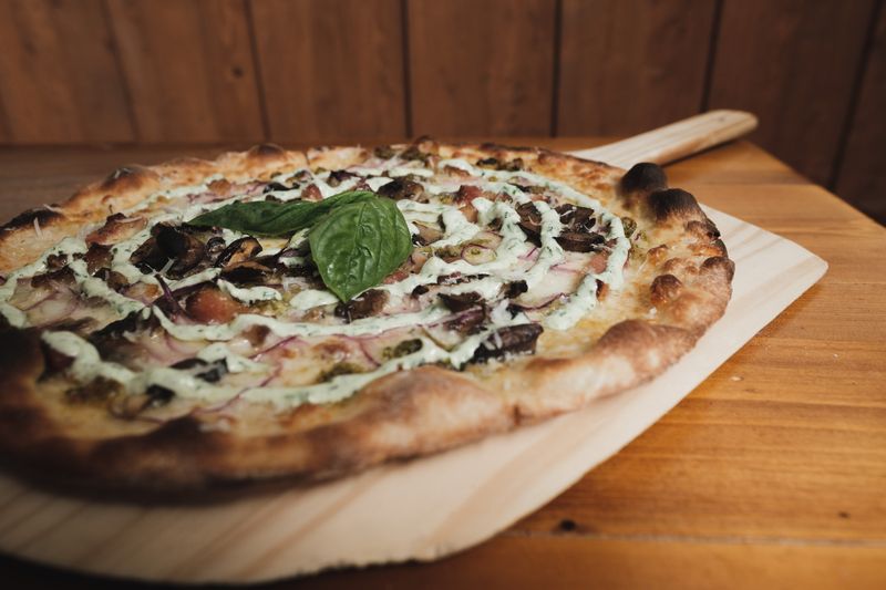 Artisan pizza with fresh toppings on a wooden board
